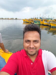 Neeranjan Kumar at Vizag Fishing Harbour with traditional fishing boats in the background